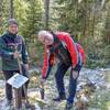 Frau Hüttner (l.) und Frank Kober setzten den kleinen Baum in den Waldboden.